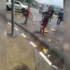 Vecinos de Santiago de Cuba recogen latas de malta caídas desde un camión