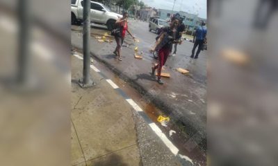 Vecinos de Santiago de Cuba recogen latas de malta caídas desde un camión